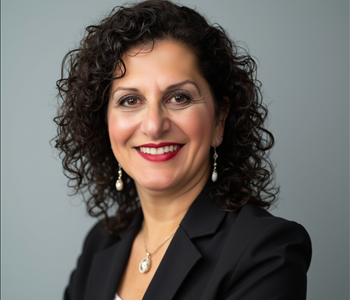 woman with black curly hair and black blazer