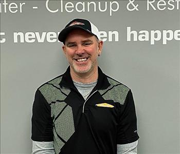 smiling bearded man with a black and green Servpro shirt on