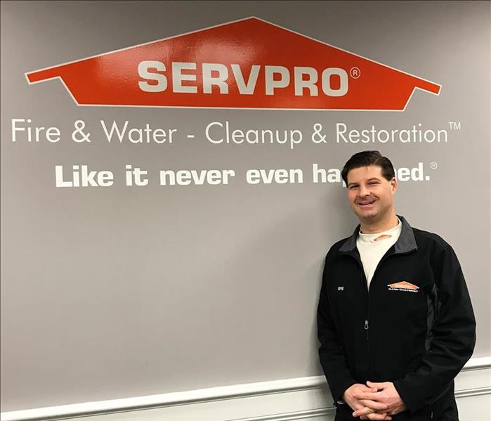 man standing in front of a servpro sign