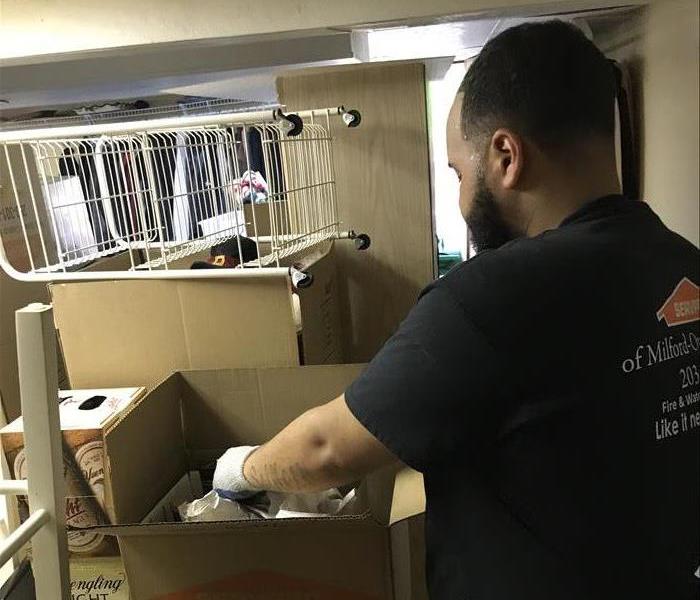 Man with Servpro shirt on packing items into a box
